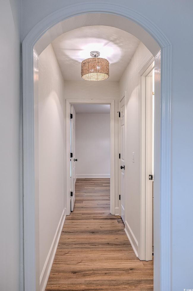 Hall featuring arched walkways and light wood finished floors | Image 30