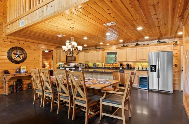 Dining area with recessed lighting, wooden walls, a chandelier, wooden ceiling, and beverage cooler | Image 12