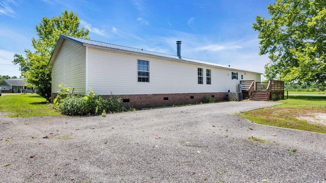 Rear view of house with crawl space and a wooden deck | Image 22