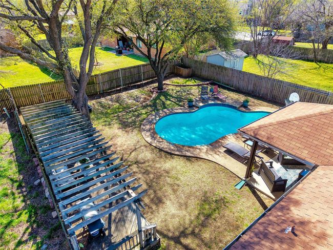 View of swimming pool featuring a fenced backyard, a fenced in pool, a yard, and a patio area | Image 29
