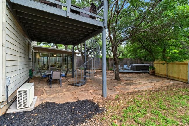 Step outside to your very own backyard oasis. Enjoy evenings around the custom flagstone fire pit, take a soak in the hot tub on its dedicated wooden deck, or dine under the stars on the spacious patio. The oversized side yard offers room for games, pets, or gardening, all under the shade of mature trees | Image 24