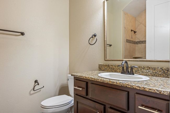 Bathroom featuring a textured wall, vanity, and a tile shower | Image 33
