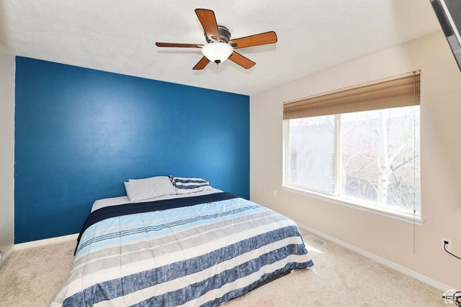 Carpeted bedroom featuring ceiling fan, baseboards, and visible vents | Image 21