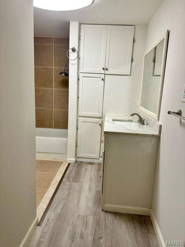 Bathroom featuring hardwood / wood-style floors, vanity, and tiled shower / bath combo | Image 30