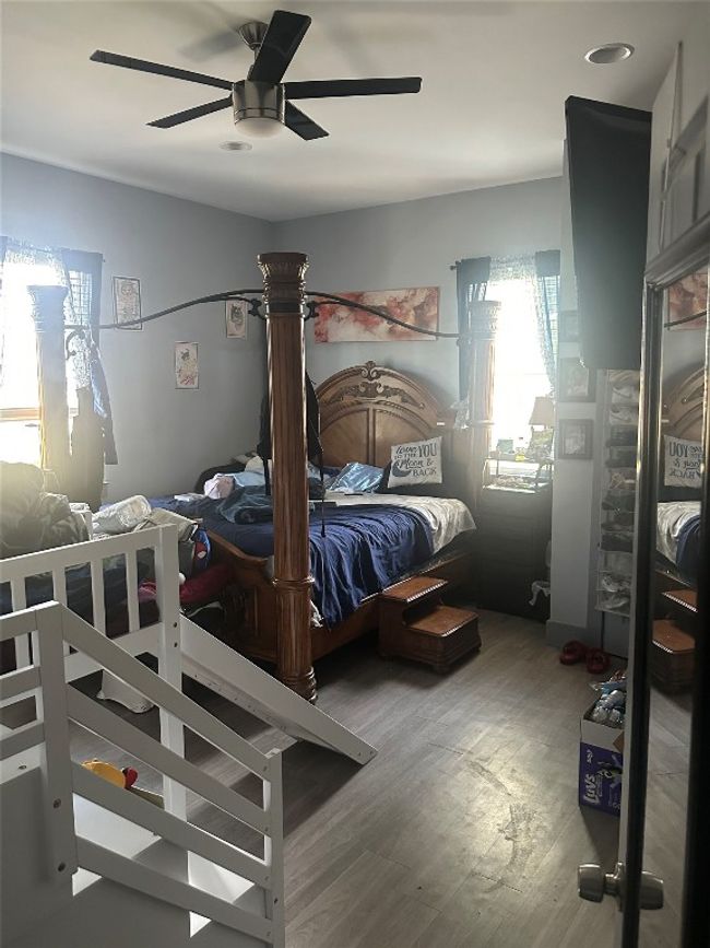 Bedroom with wood finished floors and a ceiling fan | Image 37