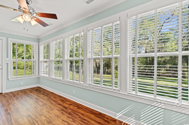 Unfurnished sunroom featuring plenty of natural light, wood finished floors, and crown molding | Image 18