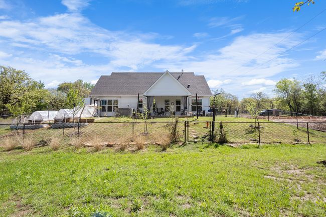 Rear view of house with a yard, roof with shingles, a fenced backyard, and a gate | Image 38