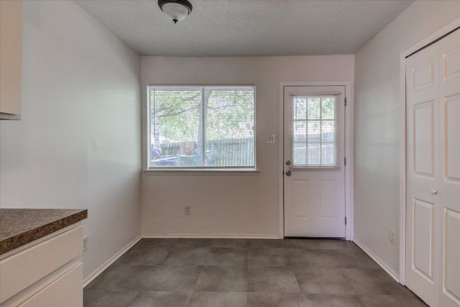 Unfurnished dining area featuring a textured ceiling and baseboards | Image 10