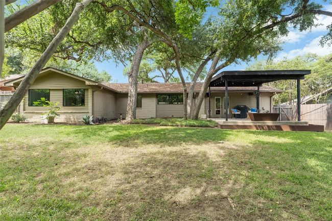 Soaring mature shade trees tower over the backyard, which is also updated with professional landscaped steel edged garden/flower boxes, ready for your spring plantings. | Image 10