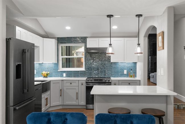 The kitchen is a masterpiece with updated appliances, quartz countertops, and custom cabinetry that balances form and function beautifully | Image 9