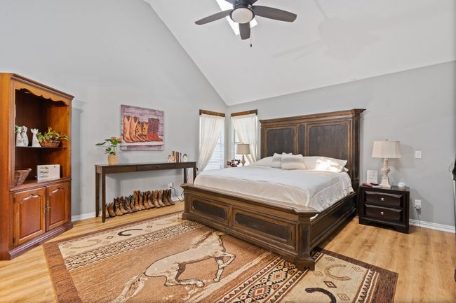 Bedroom featuring high vaulted ceiling, light wood finished floors, and a ceiling fan | Image 12