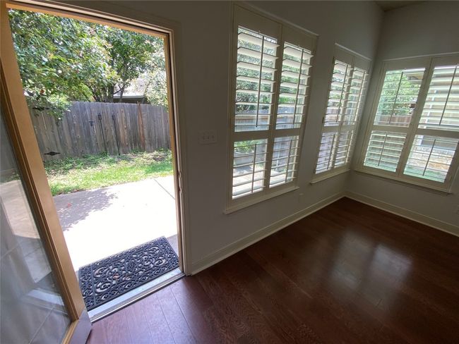 Back door from living room opens to patio and backyard with wood privacy fence. | Image 5