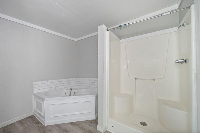 Full bath with wood finished floors, a garden tub, and a shower | Image 16