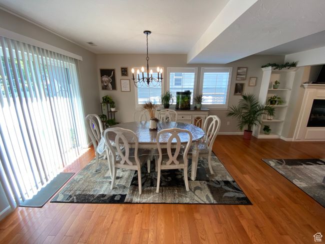 Dining area featuring a chandelier, wood finished floors, and baseboards | Image 10