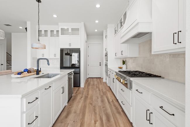 Kitchen featuring premium range hood, appliances with stainless steel finishes, tasteful backsplash, recessed lighting, and light wood-style flooring | Image 6