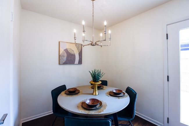 Dining space with a chandelier and dark engineered hardwood finished floors. | Image 15