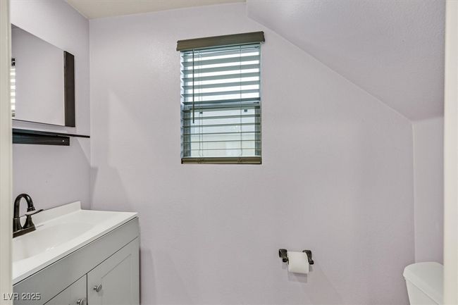 Half bath featuring lofted ceiling, toilet, and vanity | Image 14