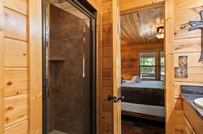 Full bathroom featuring connected bathroom, vanity, a shower stall, ceiling fan, and wood walls | Image 18