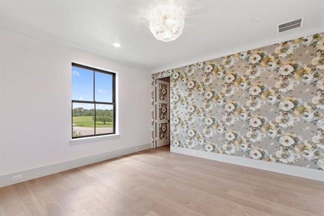 The fourth bedroom is located upstairs and has views of the front yard. Pretty wallpapers conceal a door to the oversized closet. An en-suite full bath is appointed with neutral, crisp tiles and a single basin vanity. | Image 31