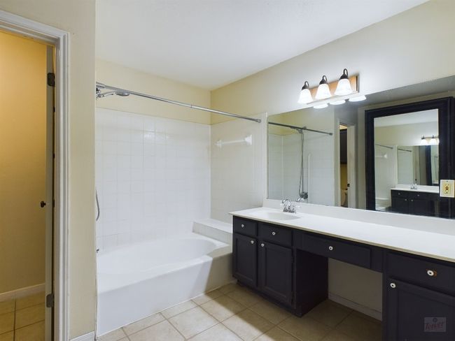 Bathroom with tile patterned flooring, bathing tub / shower combination, and vanity | Image 14