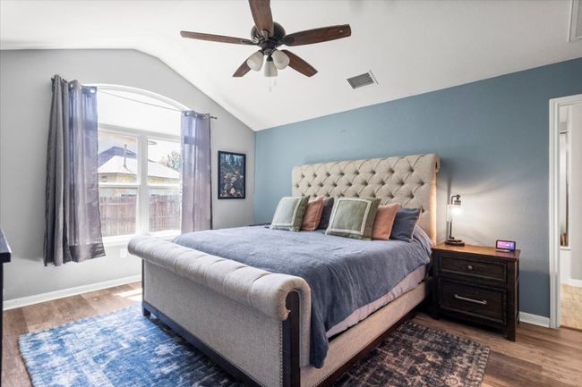 Bedroom featuring vaulted ceiling, wood laminate floors, baseboards, and ceiling fan | Image 16