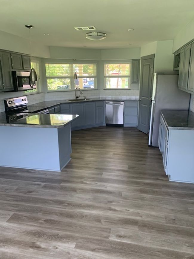 Kitchen featuring a peninsula, dishwashing machine, fridge, stove, and stainless steel microwave | Image 12
