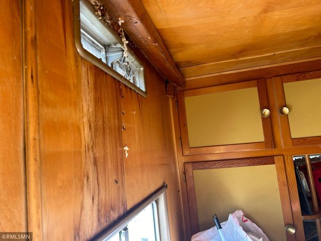 bedroom Wall and built-ins inside yellow mobile home | Image 28