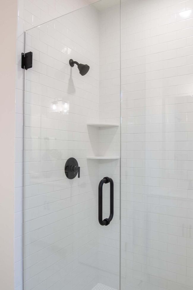 The primary bathroom features a stunning ceramic tile walk-in shower, showcasing sleek, modern design with beautiful tiles. Photos are from previously built home; options and features will vary. | Image 20
