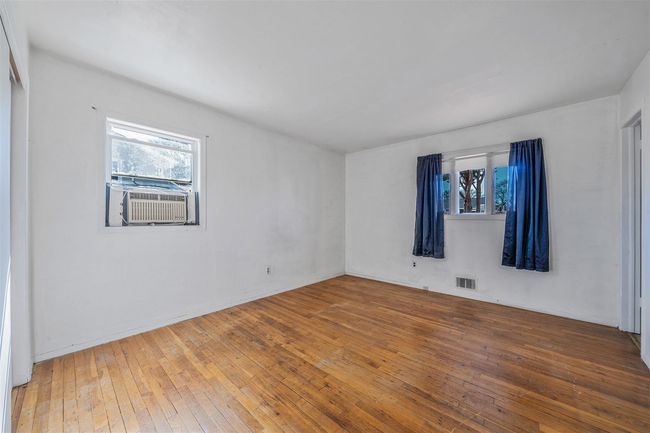 Unfurnished room with hardwood / wood-style floors, cooling unit, and visible vents | Image 19