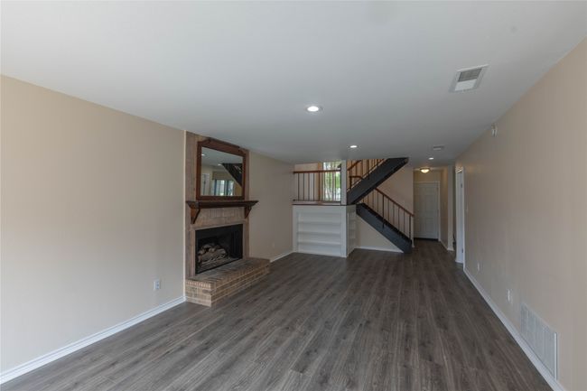 Unfurnished living room with wood finished floors, stairway, baseboards, and recessed lighting | Image 32