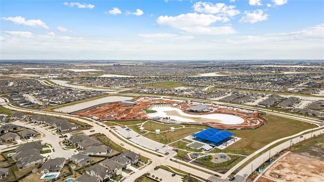 A wide aerial view of the neighborhood highlighting the future lagoon-style pool (slated for completion this summer) and surrounding residential community. | Image 25