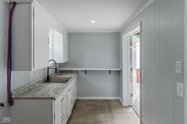 laundry room with a sink, crown molding, and baseboards | Image 46