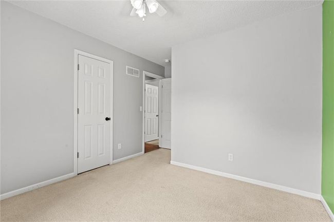 Unfurnished bedroom featuring carpet, ceiling fan, and a textured ceiling | Image 25