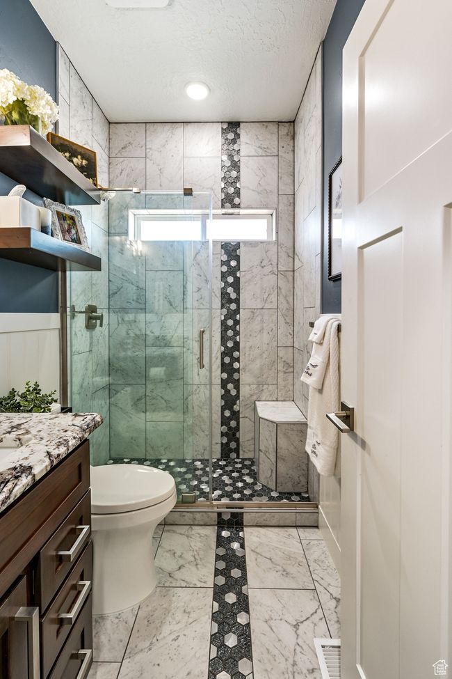 Bathroom featuring vanity, a textured ceiling, a shower stall, and marble finish floors | Image 53