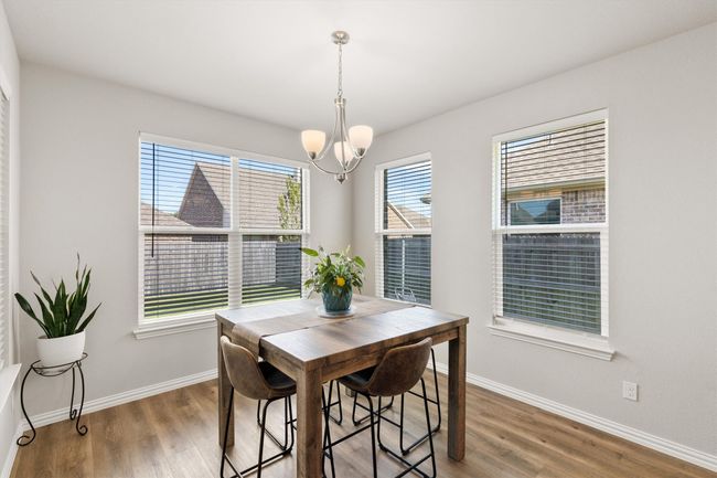 Dining area featuring a chandelier and wood finished floors | Image 11