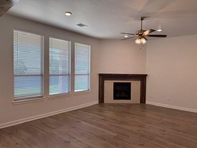 Unfurnished living room with visible vents, ceiling fan, baseboards, recessed lighting, and wood finished floors | Image 7