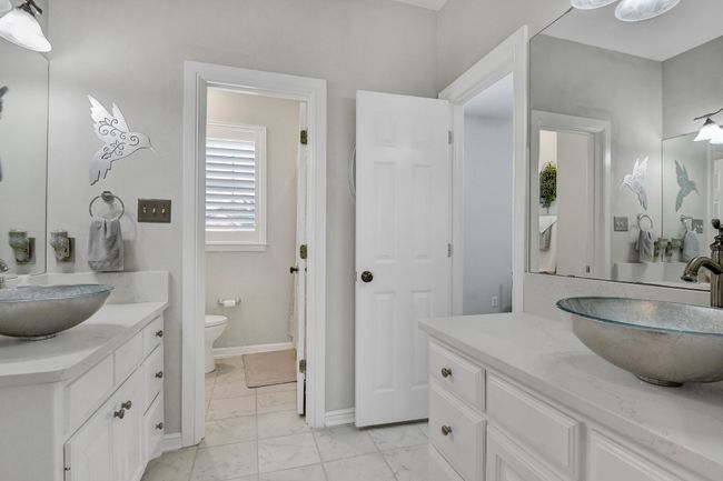 Bathroom featuring two vanities and marble look tiles | Image 24