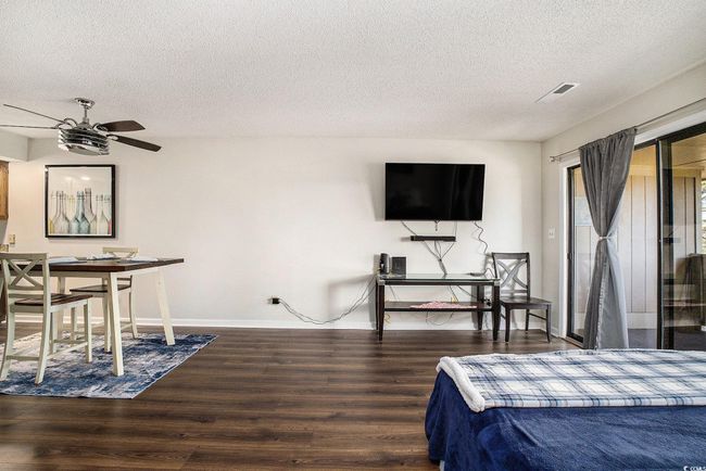 Bedroom featuring access to outside, dark wood finished floors, a textured ceiling, and a ceiling fan | Image 20
