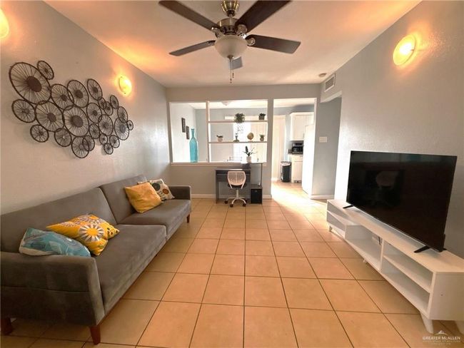 Living area with baseboards, a ceiling fan, and light tile patterned flooring | Image 4