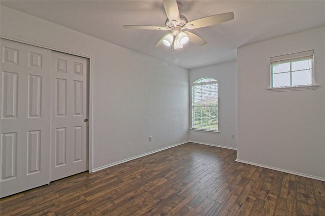 Unfurnished bedroom with dark wood finished floors, a ceiling fan, and a closet | Image 25