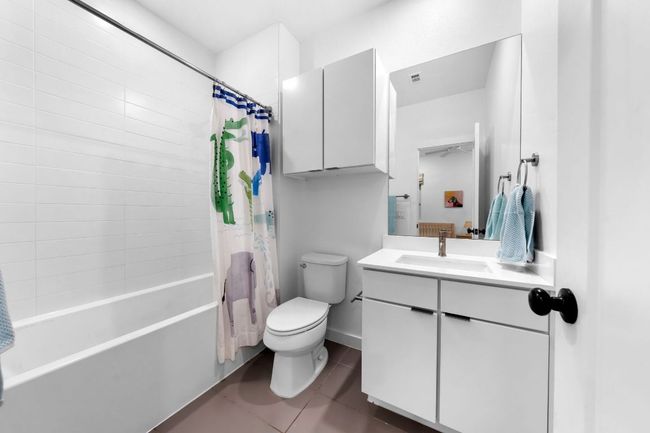 Bathroom with baseboards, toilet, vanity, shower / tub combo, and tile patterned flooring | Image 28