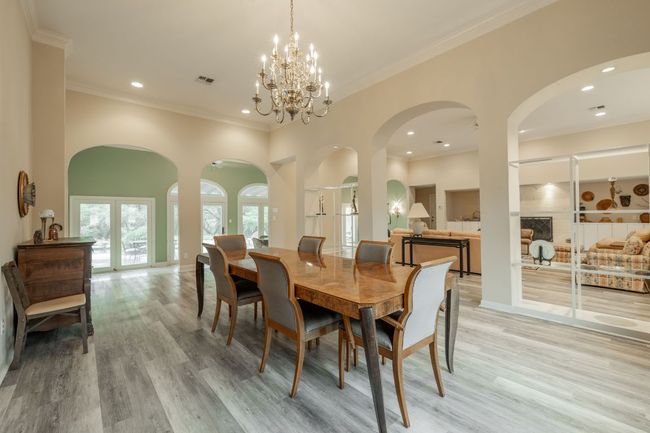 Dining space with light wood-type flooring, crown molding, a chandelier, recessed lighting, and baseboards | Image 9