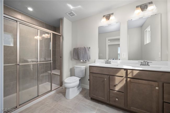 Full bath featuring a stall shower, a sink, and toilet | Image 26