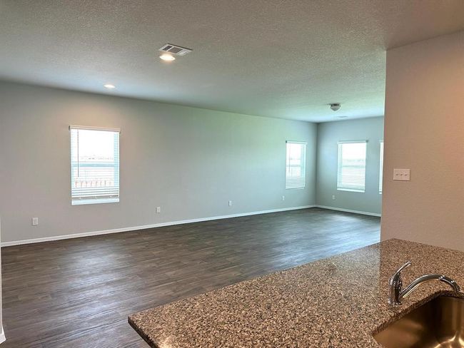 Spare room featuring a sink, dark wood-style floors, a textured ceiling, and baseboards | Image 6