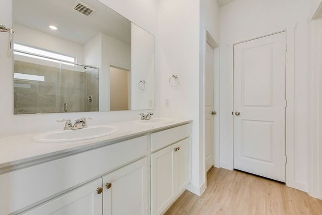 Full bath featuring tiled shower, double vanity, and wood finished floors | Image 13