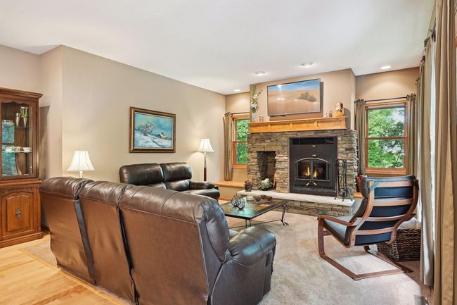 Enjoy the warmth from the wood-burning fireplace in the main-level gathering space. | Image 10