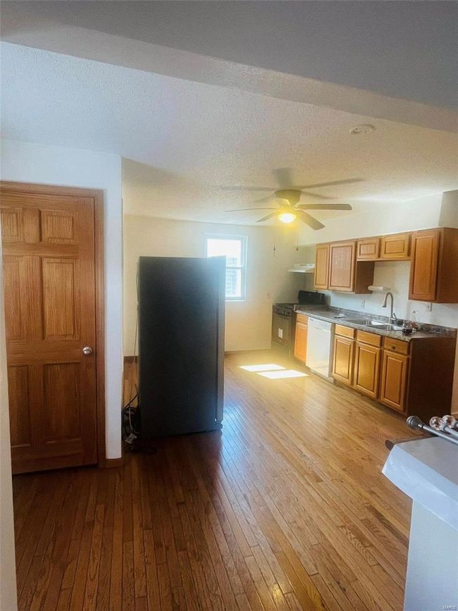 Kitchen with hardwood / wood-style floors, a sink, white dishwasher, and a textured ceiling | Image 10