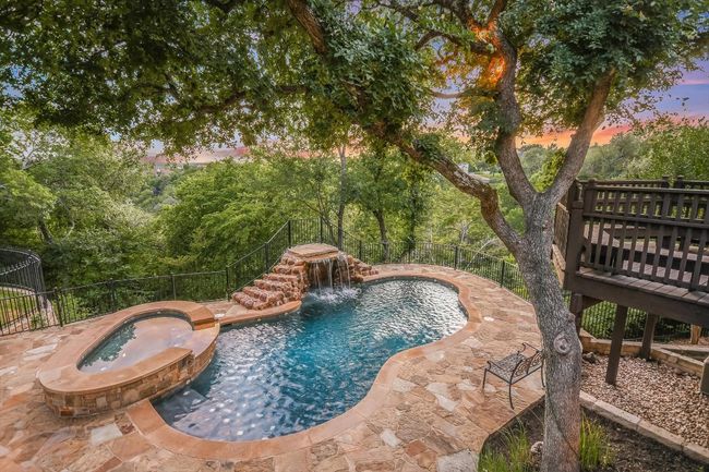 View of pool with a connected hot tub/spa, view of scattered trees trailing into the canyon below, and a patio area | Image 32