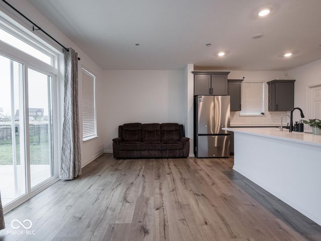 kitchen featuring light wood-type flooring, freestanding refrigerator, a sink, and plenty of natural light | Image 16