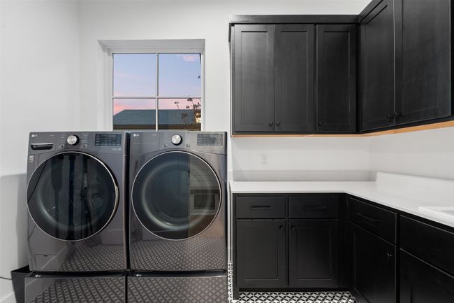 Large laundry room featuring designer tile and ample cabinet storage. | Image 32